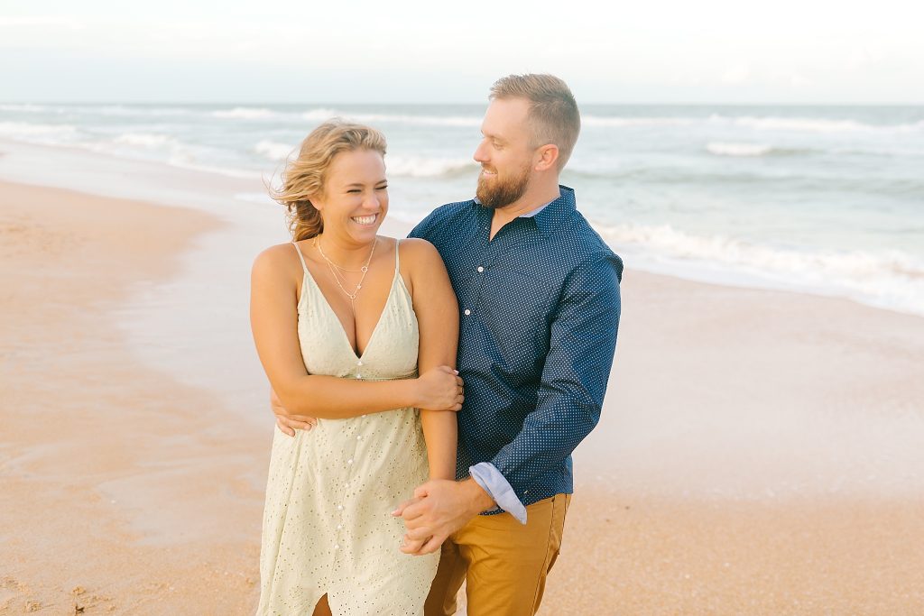 bride and groom laugh during beach photos