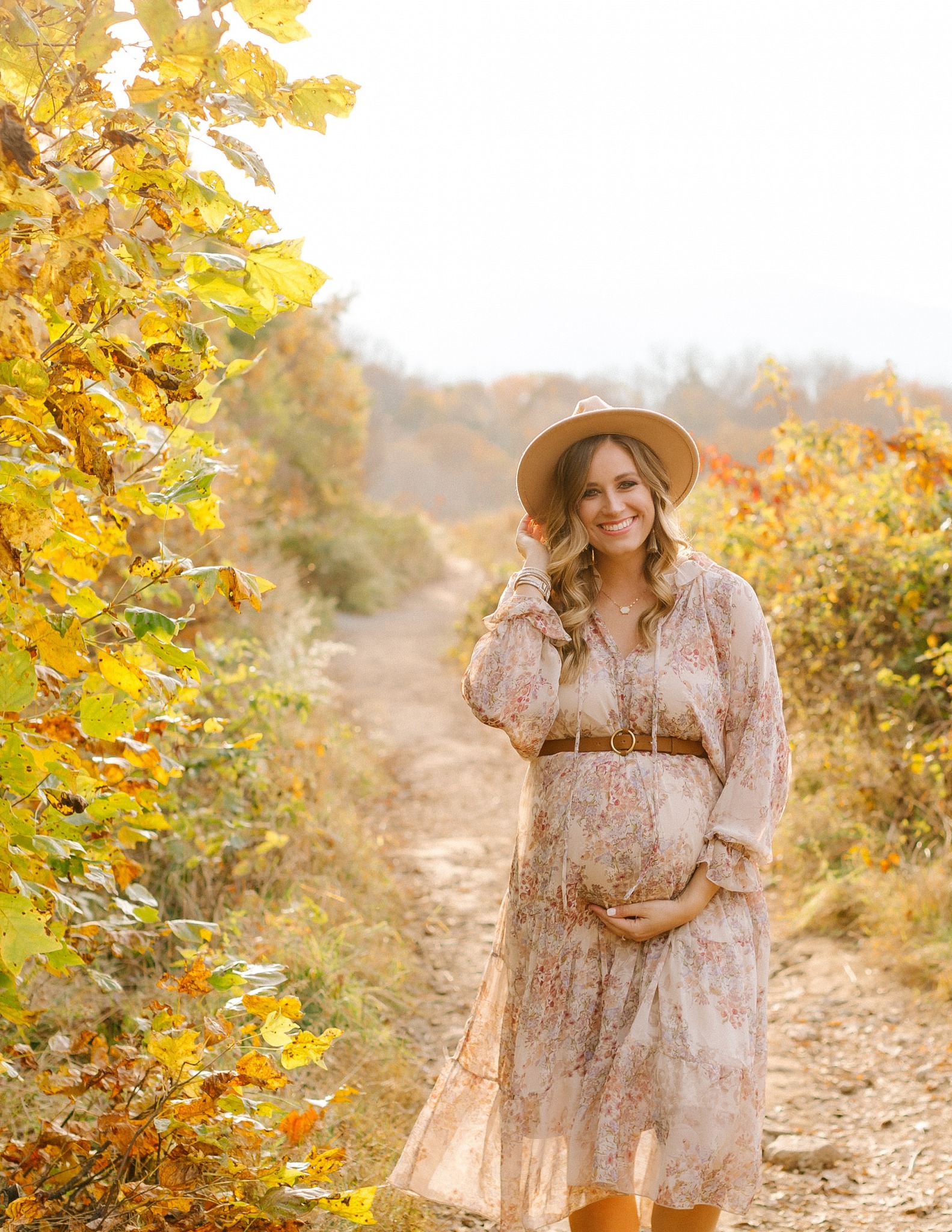 mom in broad hat smiles during Asheville maternity session