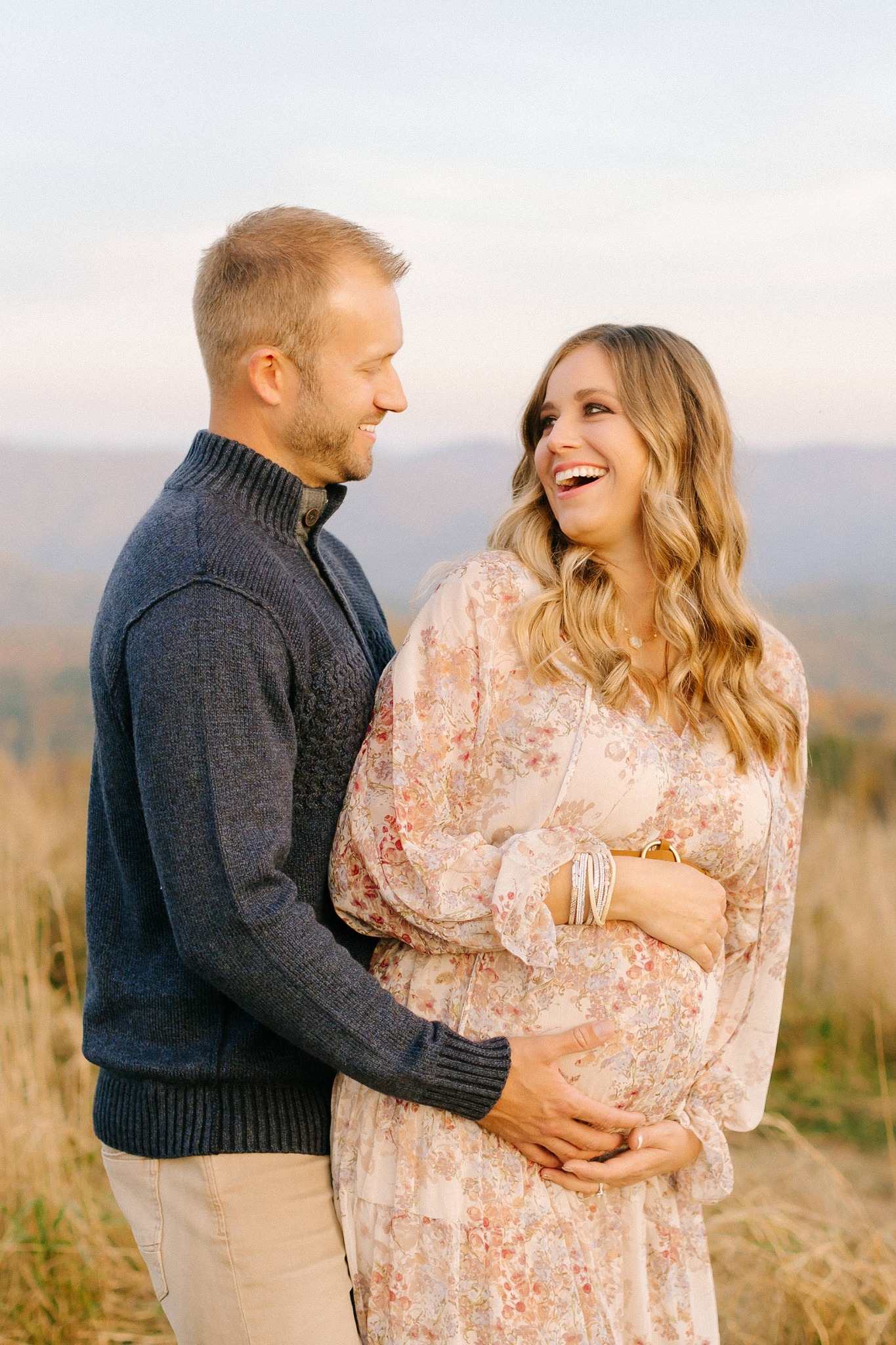 mom laughs during maternity session with dad
