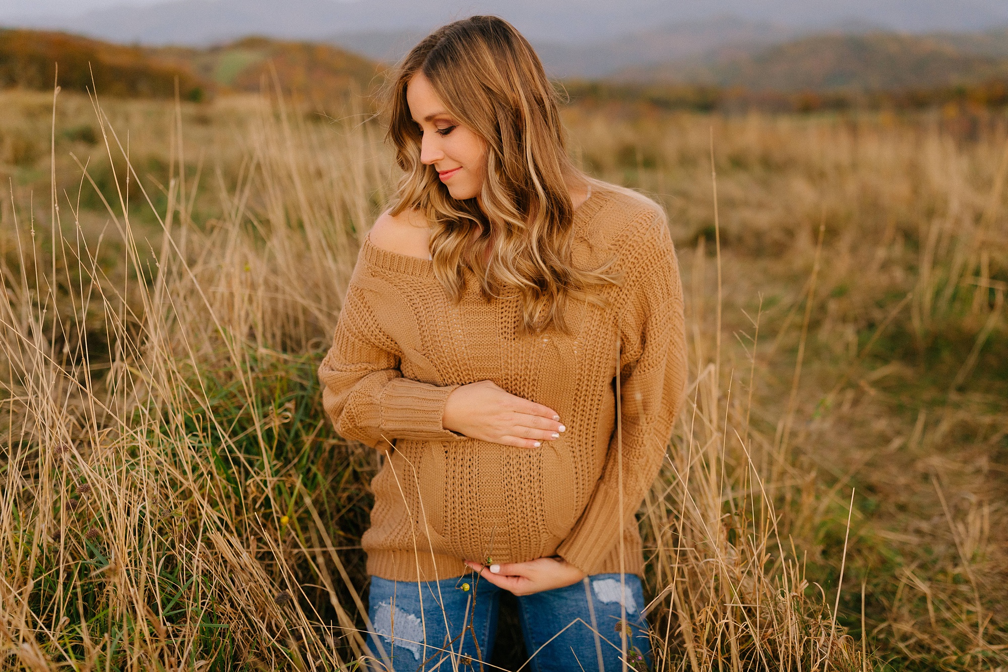 mom cradles belly during maternity session in Asheville