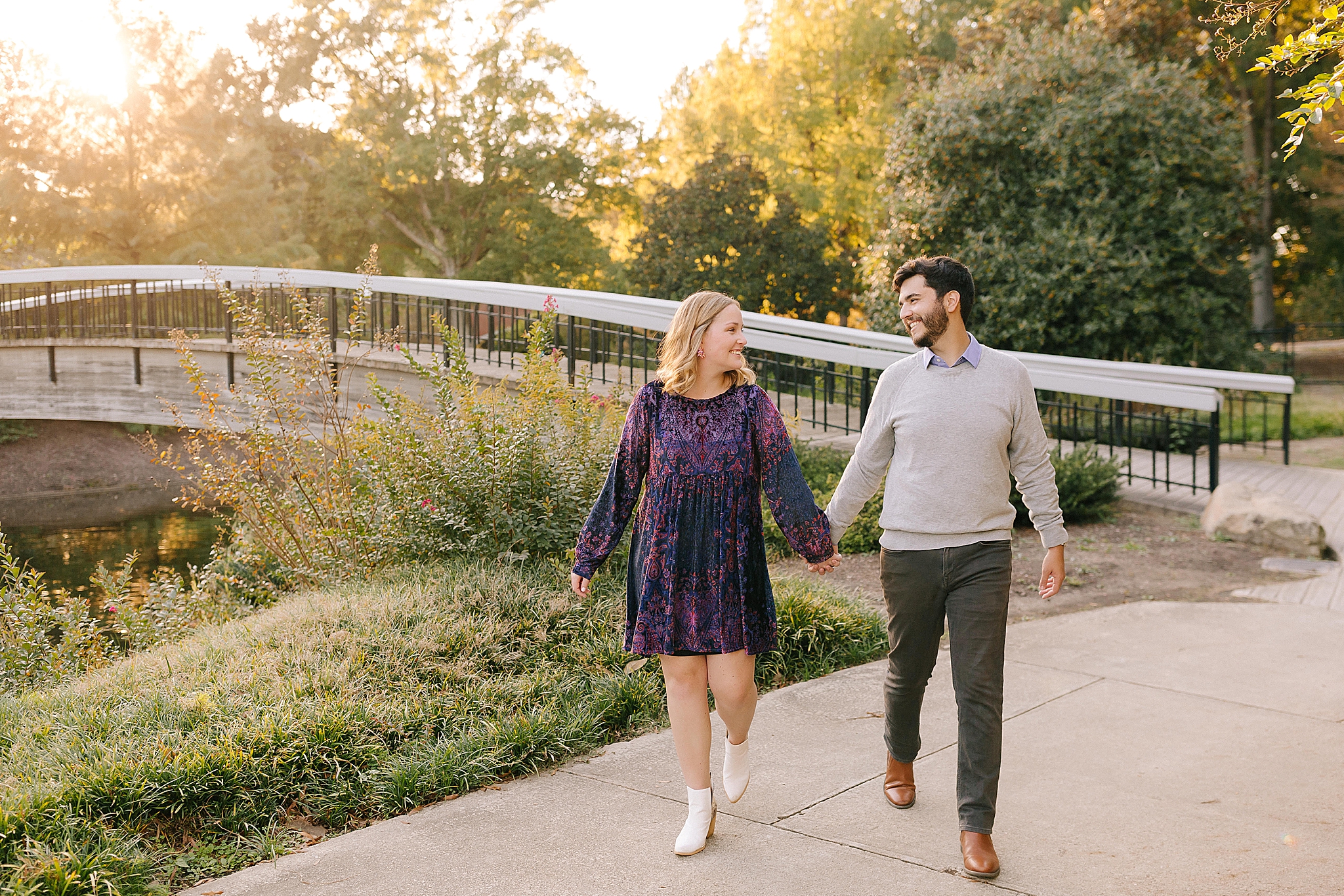couple walks by bridge in Raleigh NC park