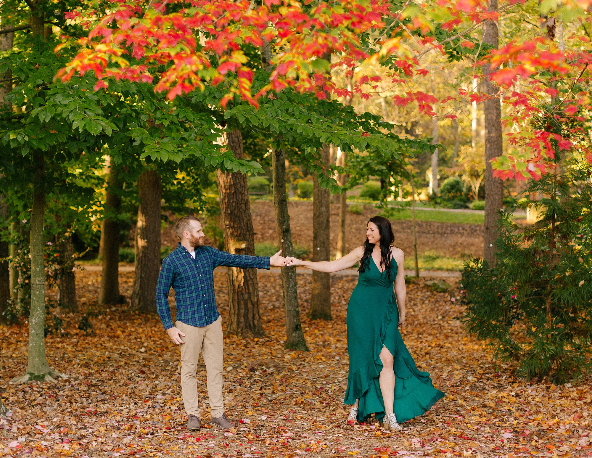 married couple laughs and dances in woods at Greensboro Botanical Gardens
