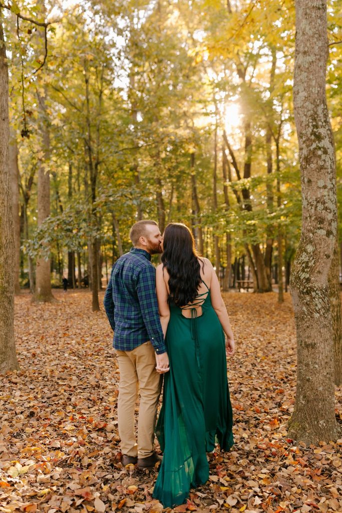 wife leans over to kiss husband during Greensboro Botanical Gardens anniversary session