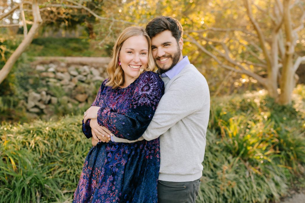 couple smiling candidly for their engagement photos at Pullen Park with NC wedding photographer Chelsea Renay
