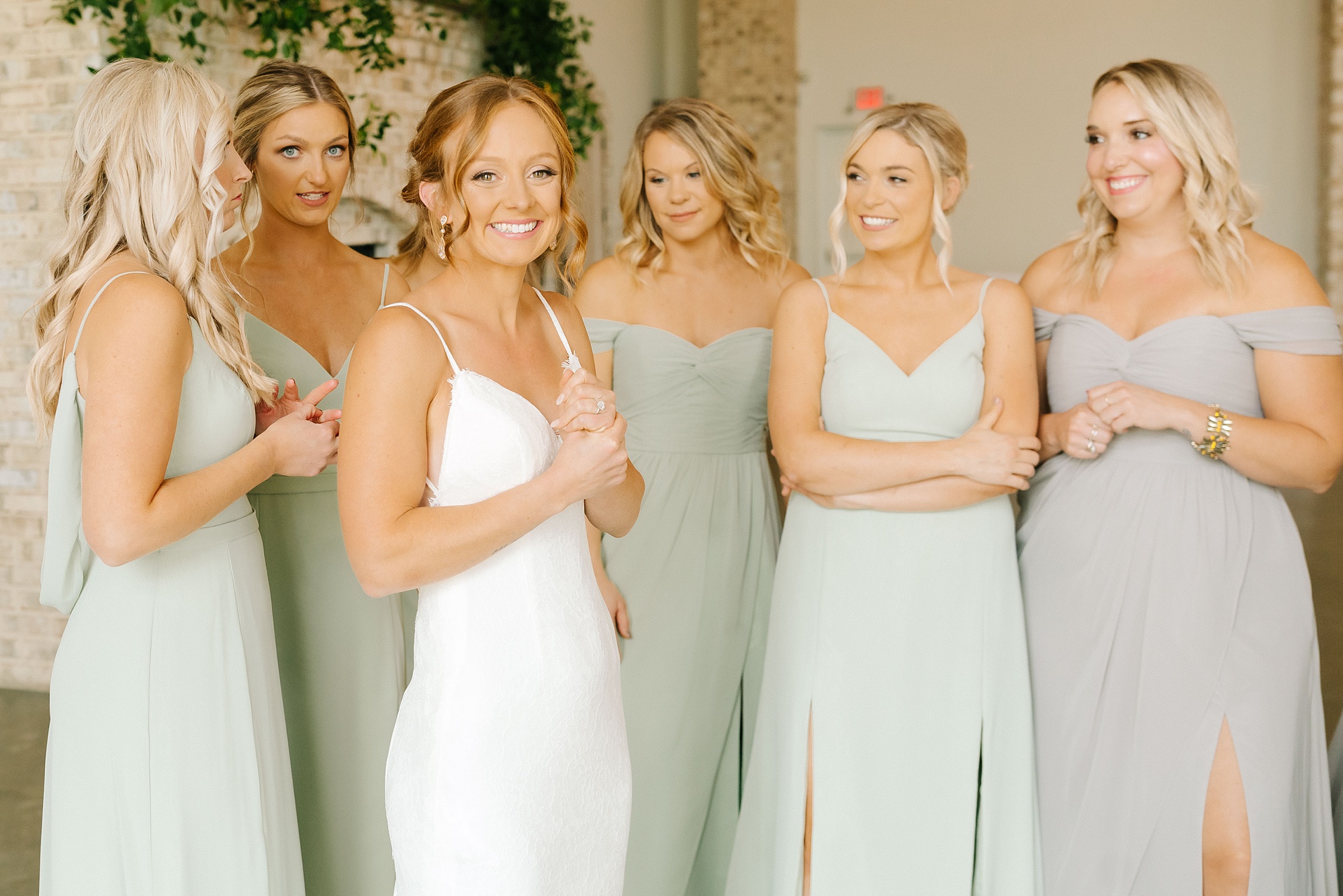 bride smiles after first look wit bridesmaids in Wrightsville Manor