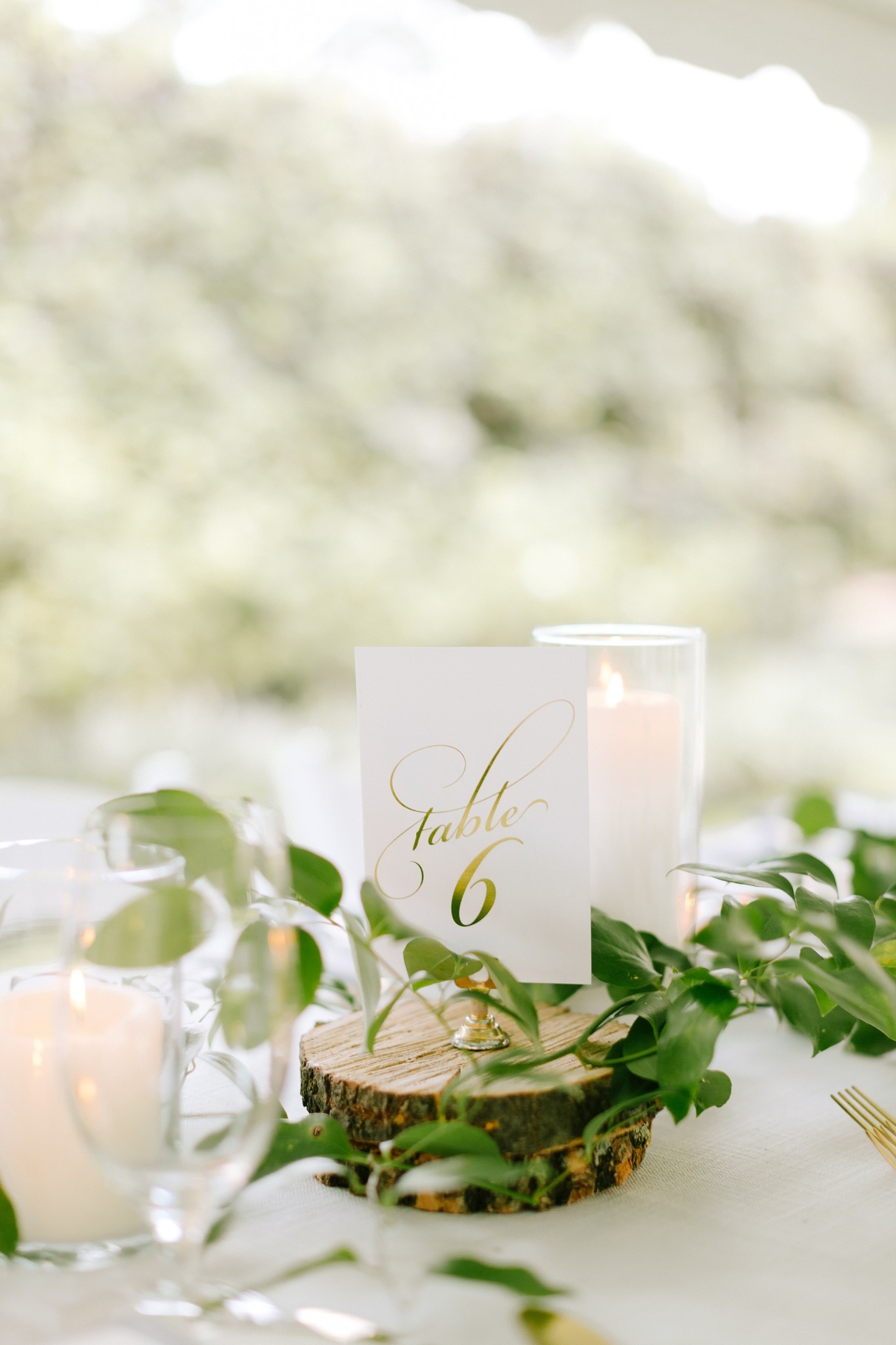 centerpieces on wooden chargers with gold table numbers 