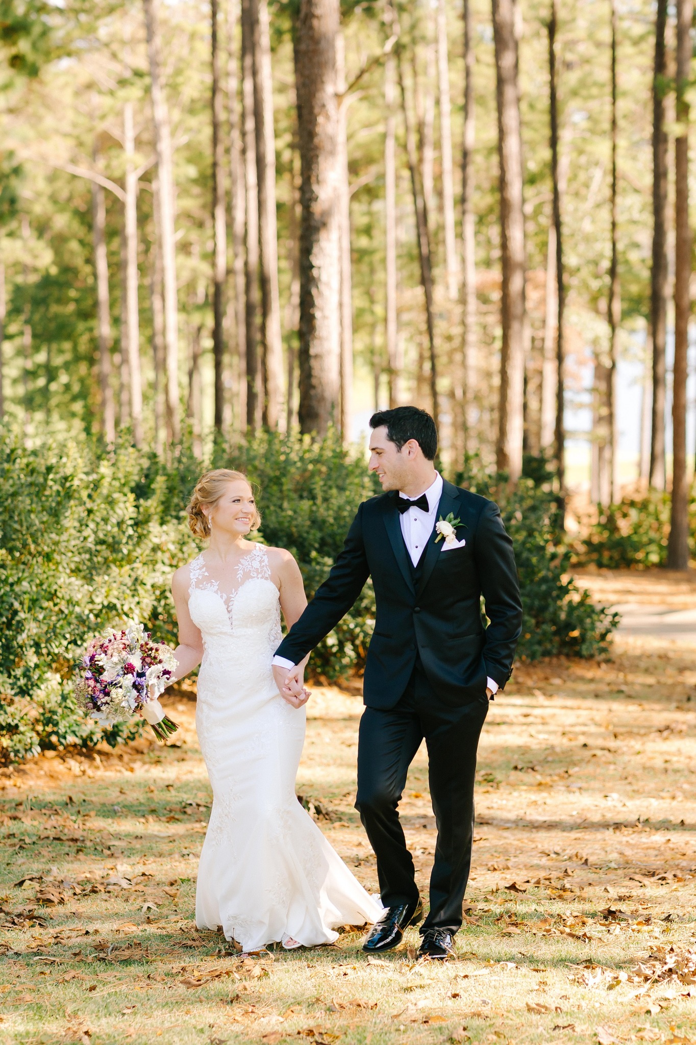 bride and groom walk through woods at Renaissance Ross Bridge