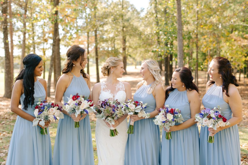 bridesmaids in pale blue gowns pose before Renaissance Ross Bridge Wedding