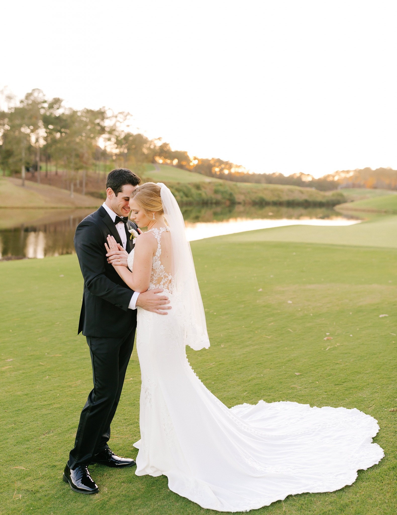 bride and groom pose on golf course at Renaissance Ross Bridge
