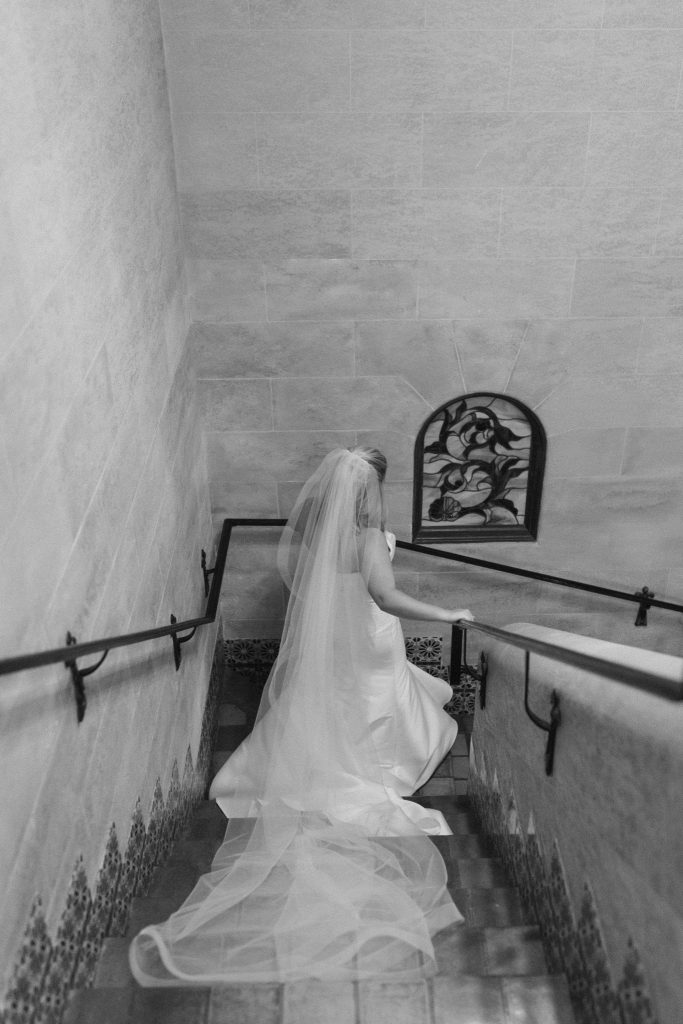 bride walks down grand staircase at Powel Crosley Estate