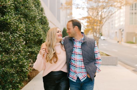 husband looks at wife while walking through city of Winston-Salem