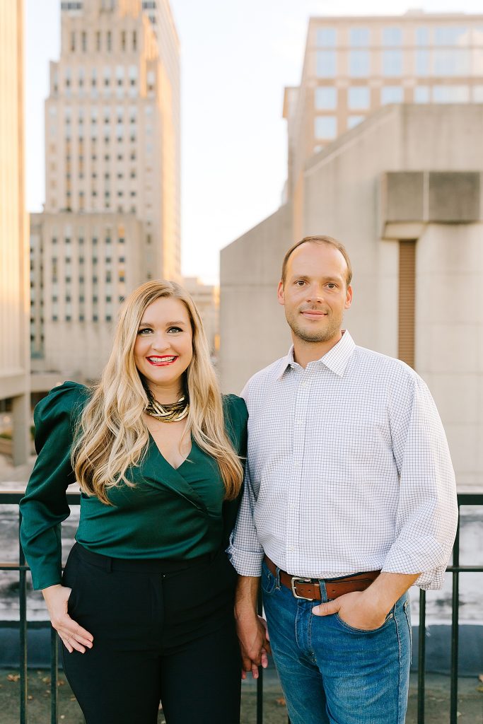 married couple poses on rooftop in Downtown Winston-Salem