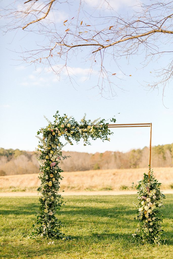 ceremony details along gold arbor at The Meadows Raleigh