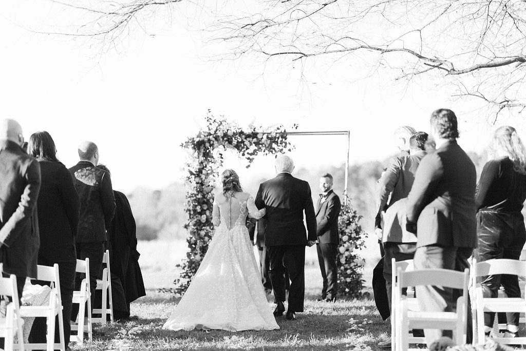 bride walks down aisle with father at The Meadows Raleigh