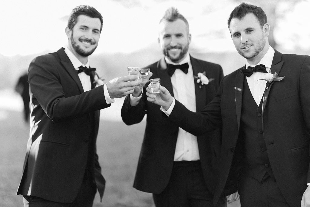 groom toasts with groomsmen outside The Meadows Raleigh