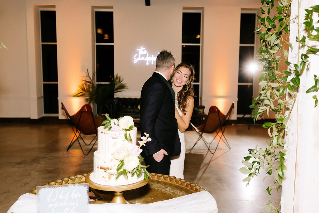 bride and groom laugh before cake cutting
