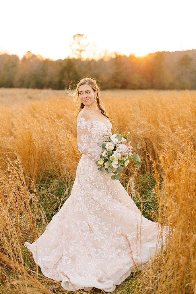 Raleigh NC bride poses in field with lace gown