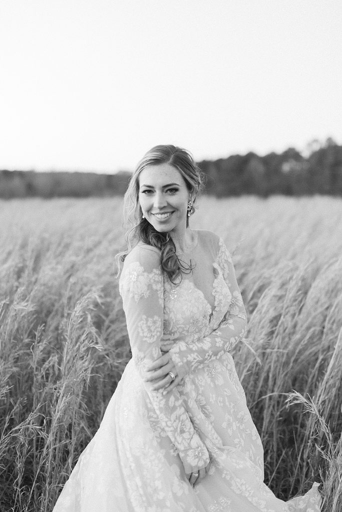 bride poses in field at The Meadows Raleigh