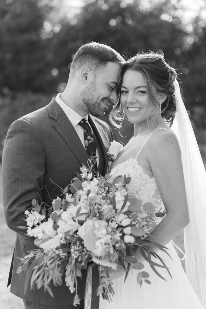 newlyweds touch heads together during wedding photos