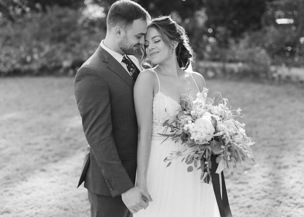 bride and groom hold hand while standing back to front