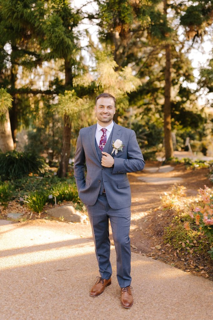 groom holds lapel in blue suit