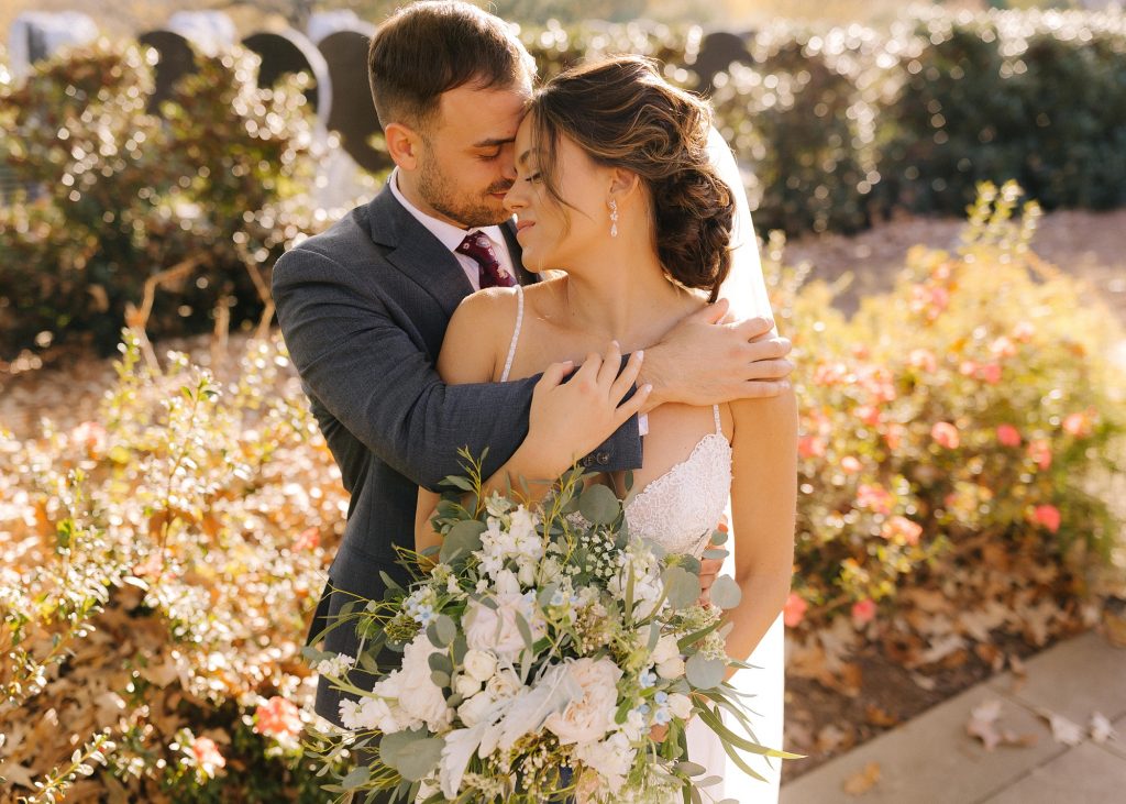 groom wraps arms around bride during wedding photos in Downtown Atlanta