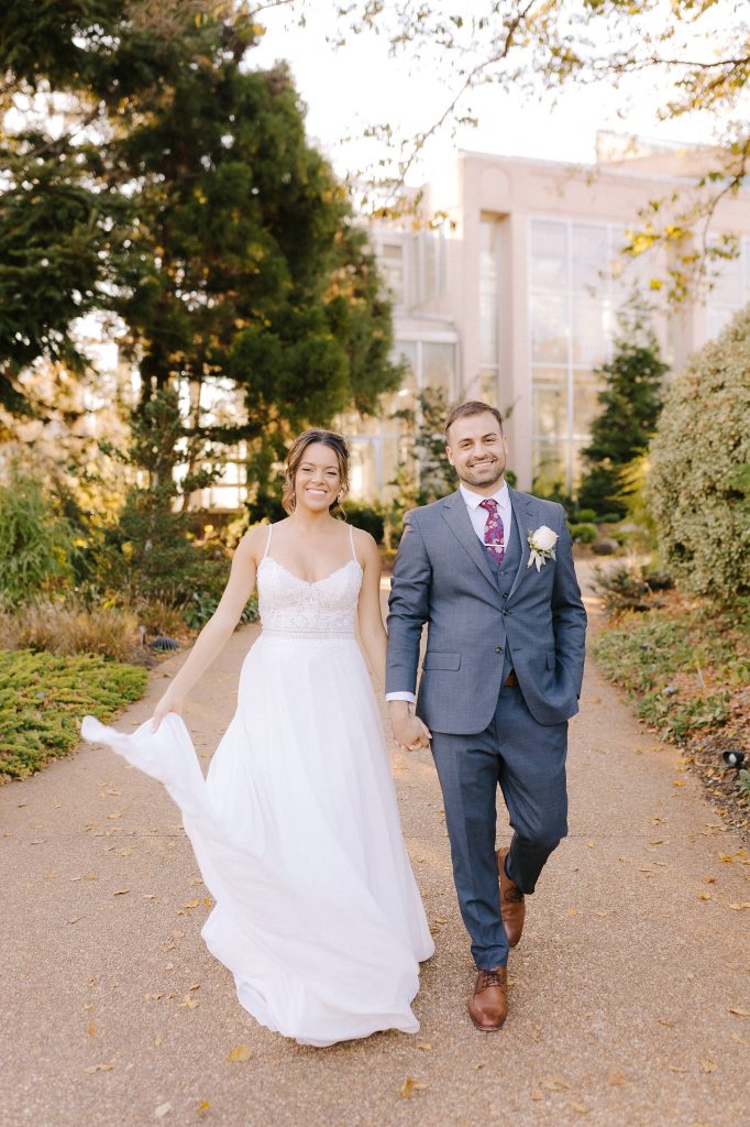 bride and groom hold hands walking through Atlanta garden