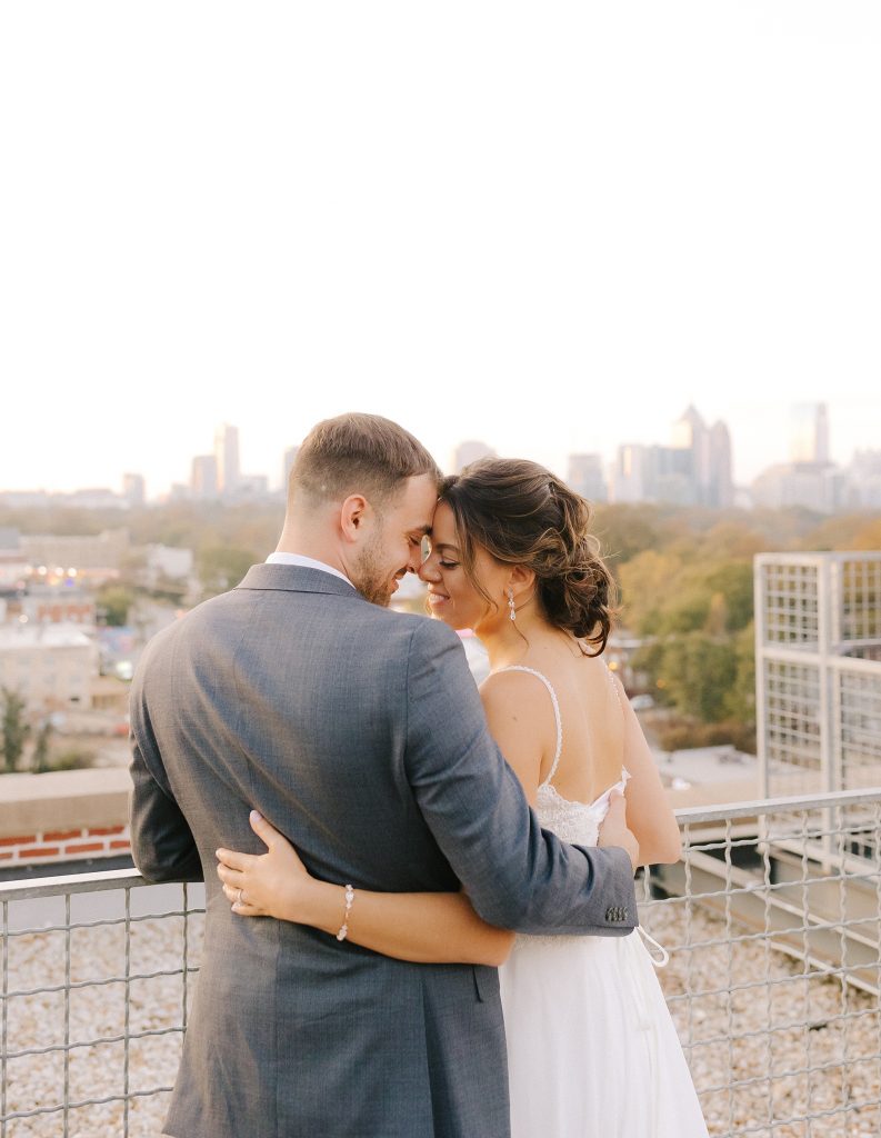 newlyweds pose on rooftop in Downtown Atlanta