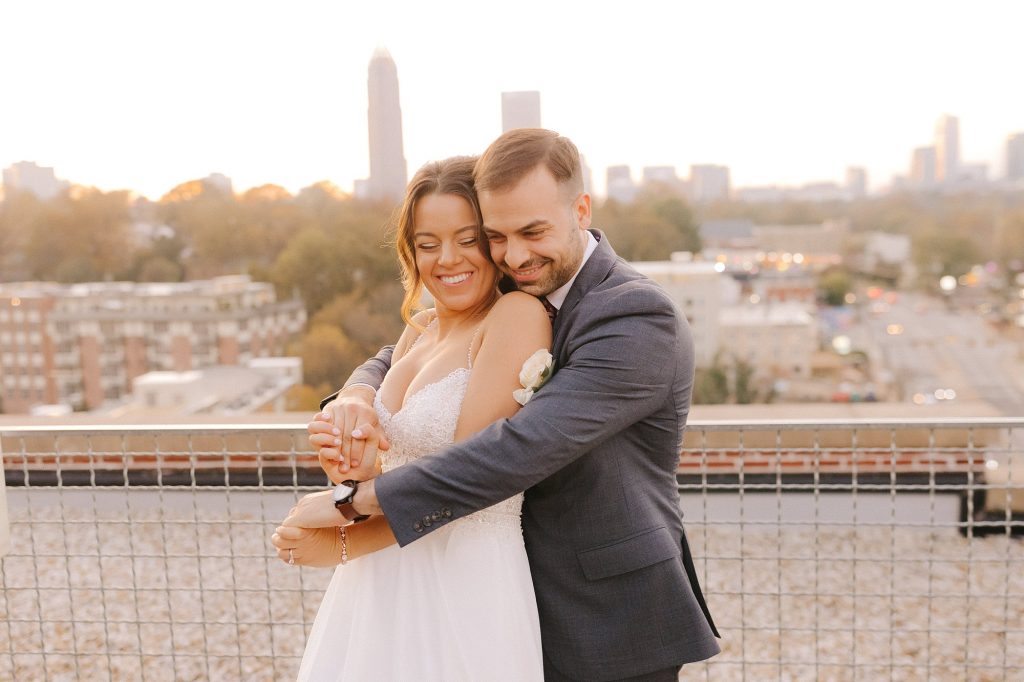bride and groom hug on rooftop in Downtown Atlanta