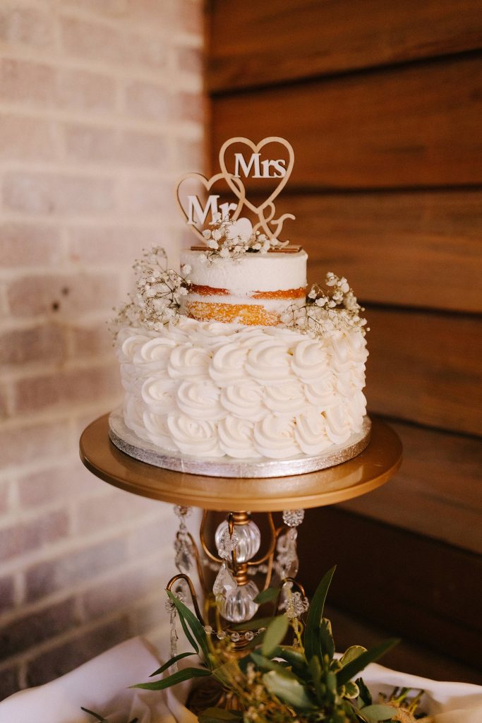 wedding cake with gold details and heart topper