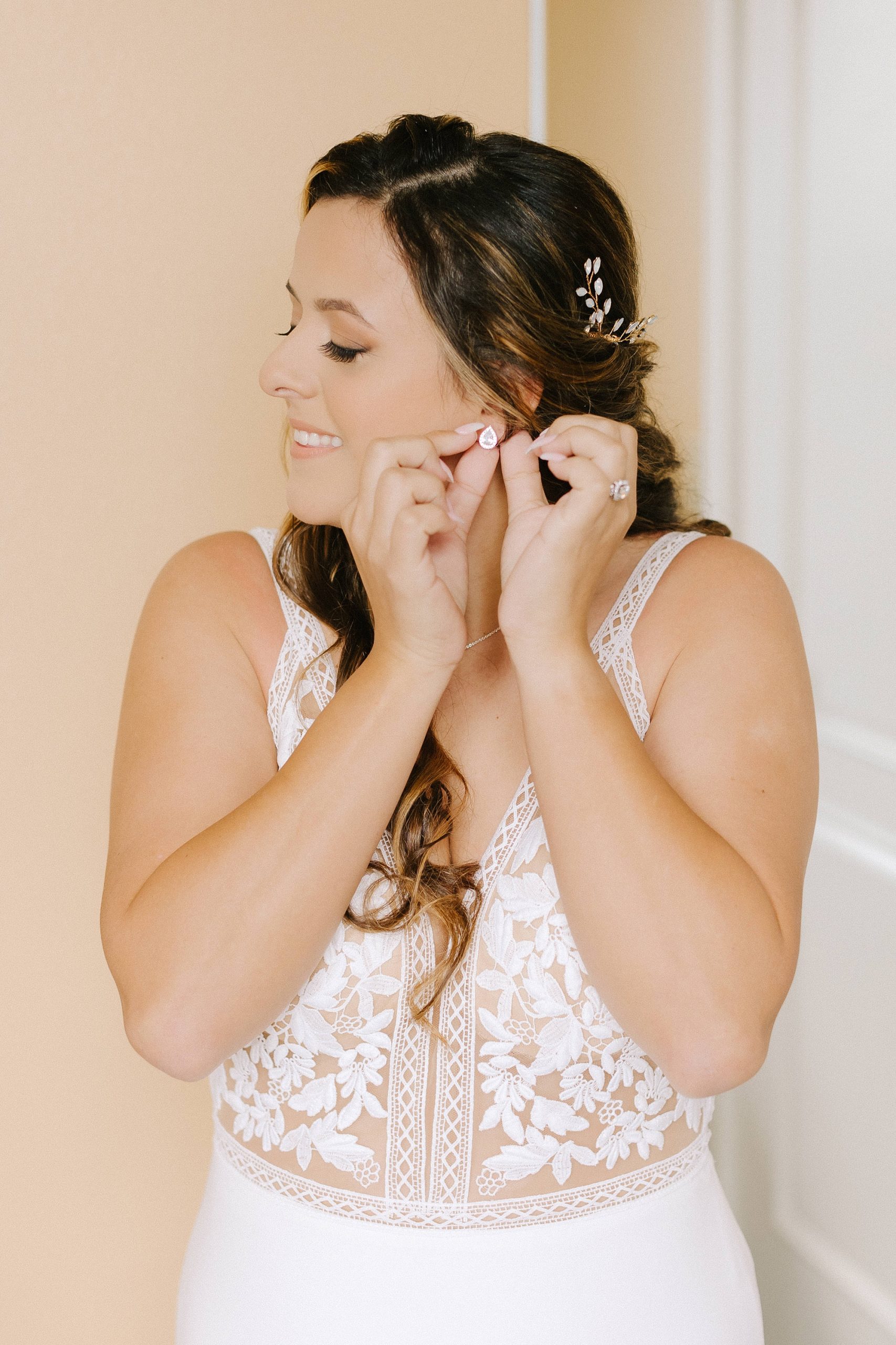 bride adjusts earrings before Florida wedding day