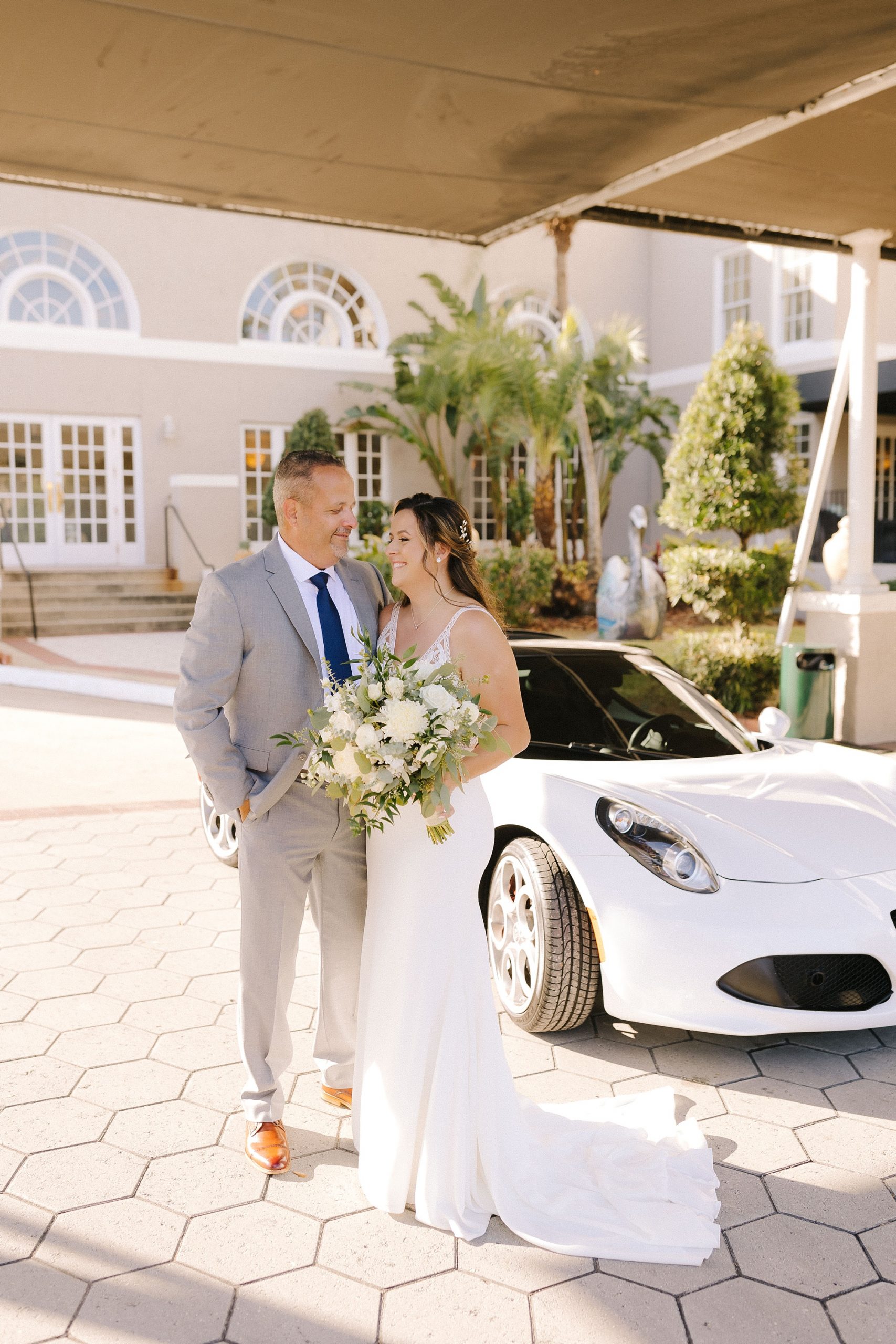 bride and father have first look outside Florida hotel by sports car
