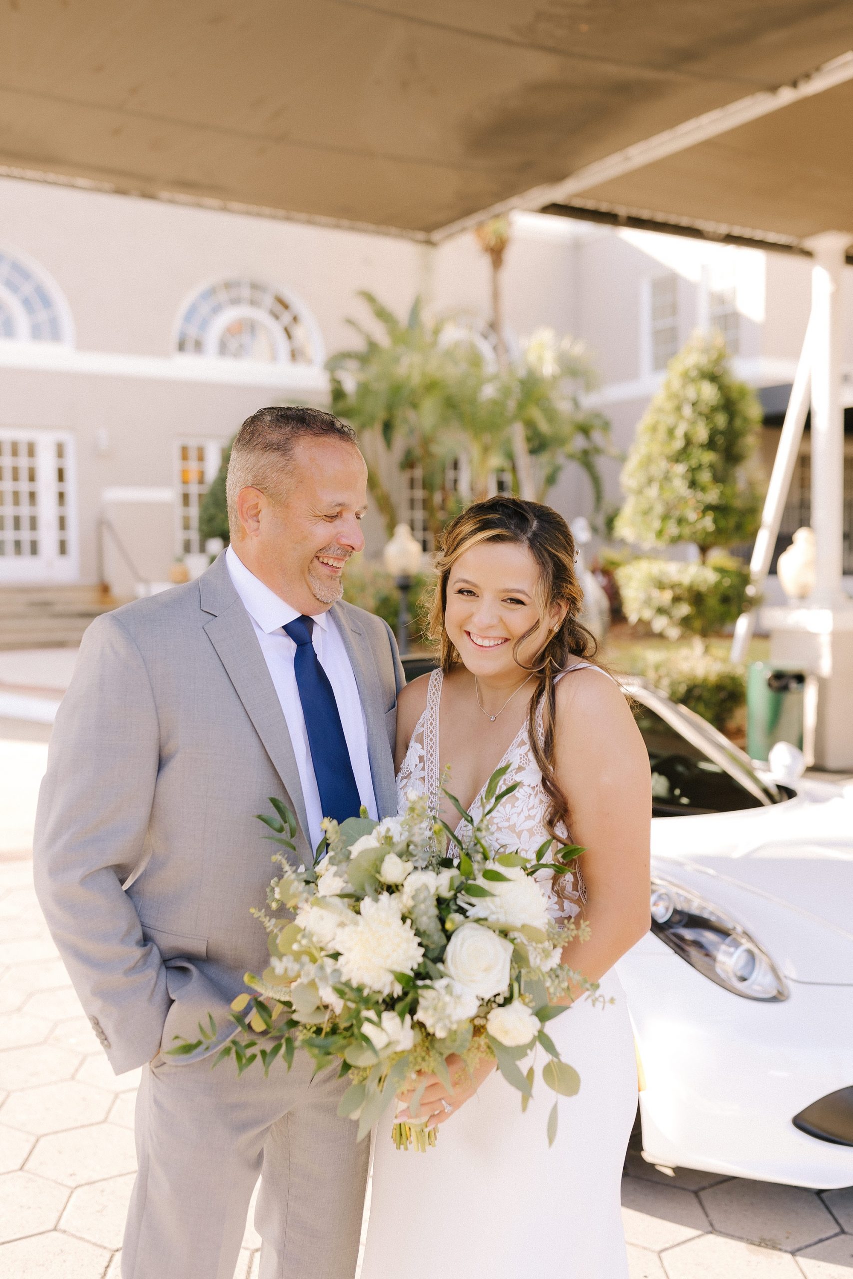 bride has first look with father by sports car in Florida 