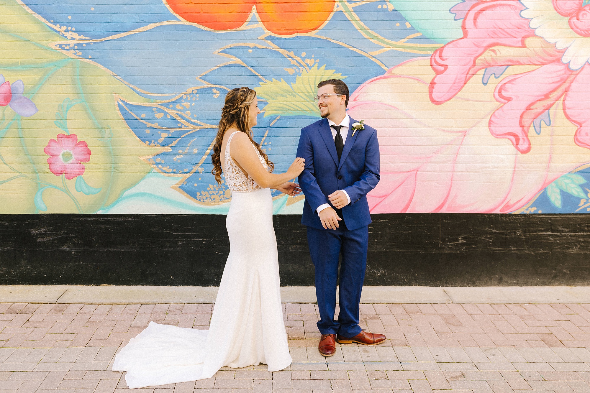 bride and groom have first look in front of colorful mural in downtown Lakeland