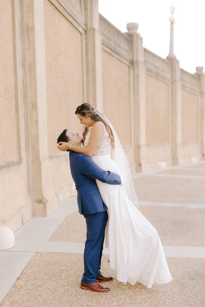 groom lifts bride during Downtown Lakeland wedding portraits 