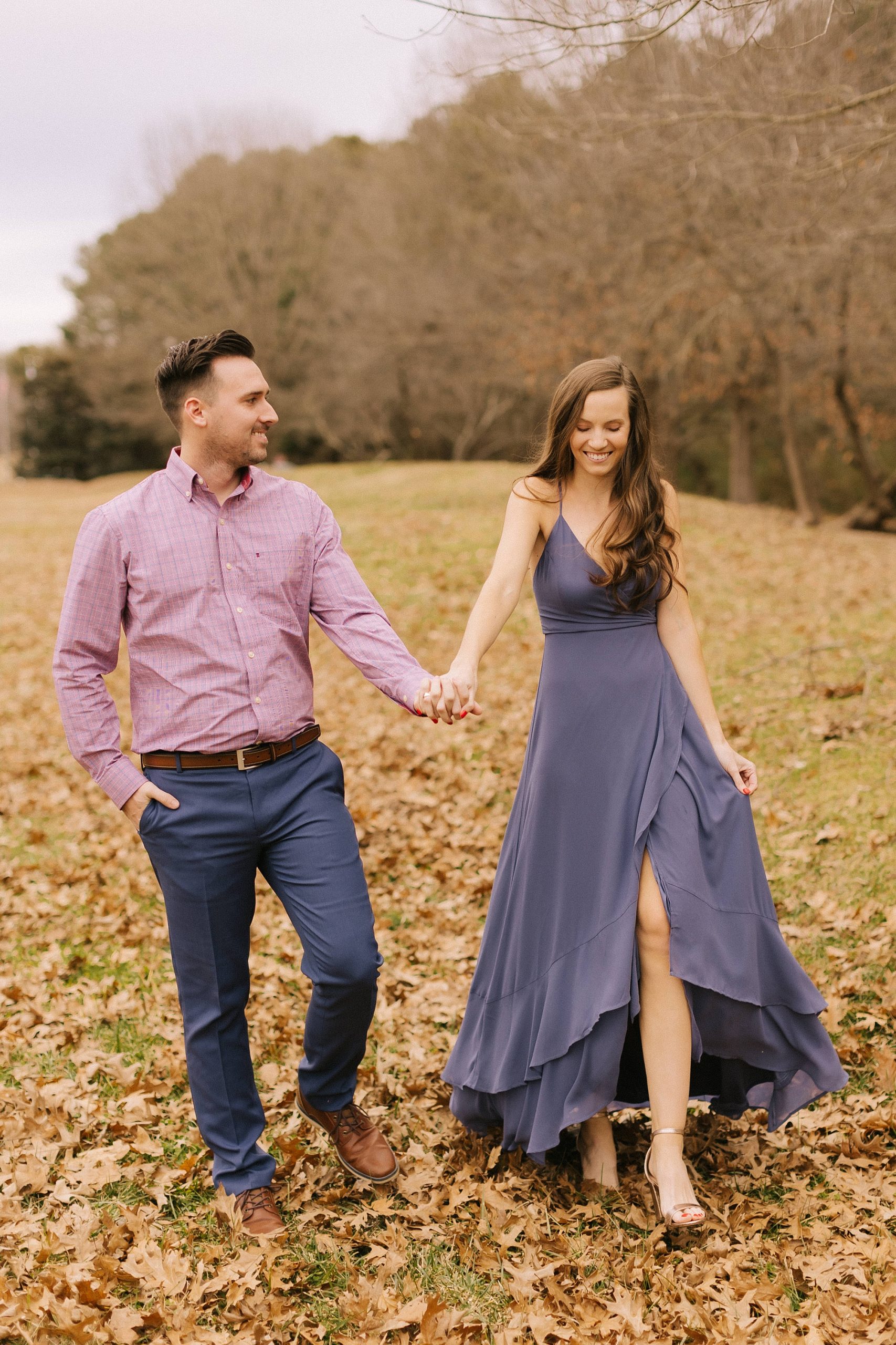 couple walks through fall leaves during Jetton Park engagement session