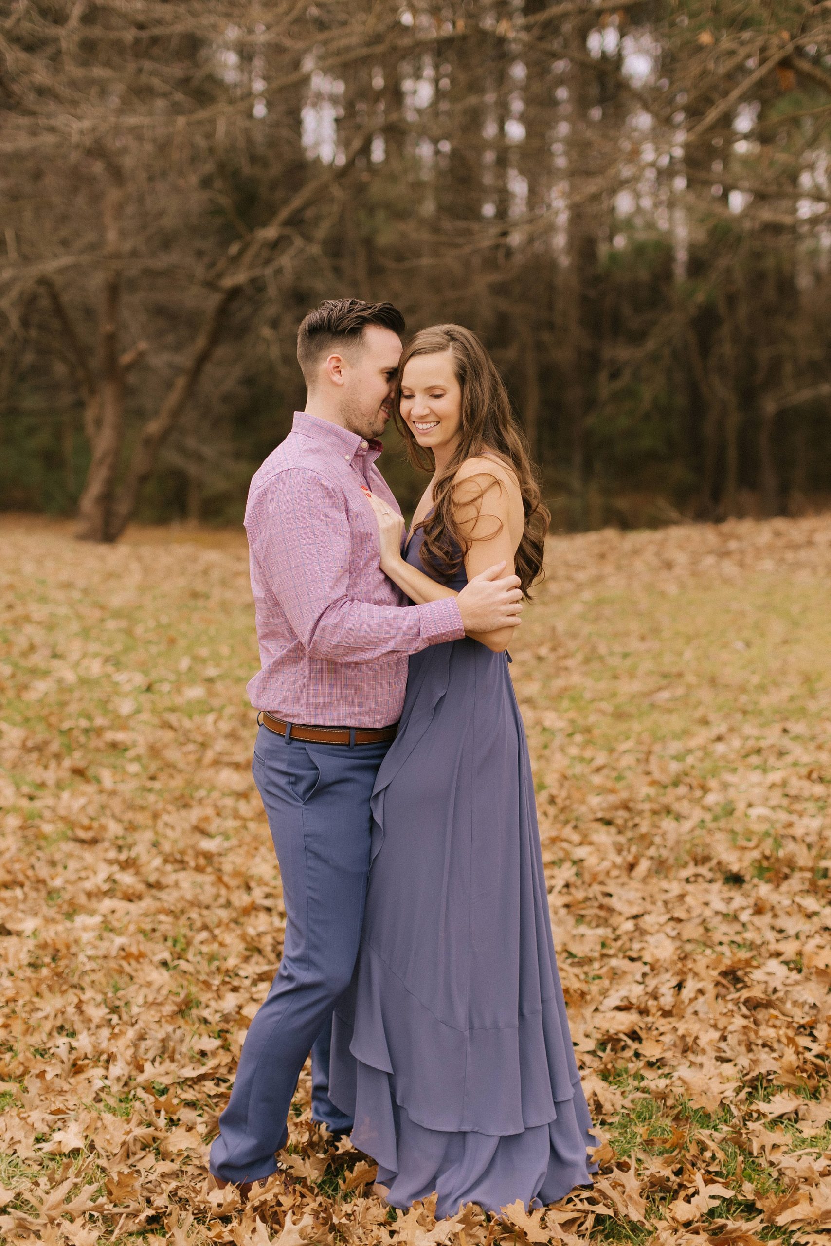 couple laughs together during fall engagement photos 