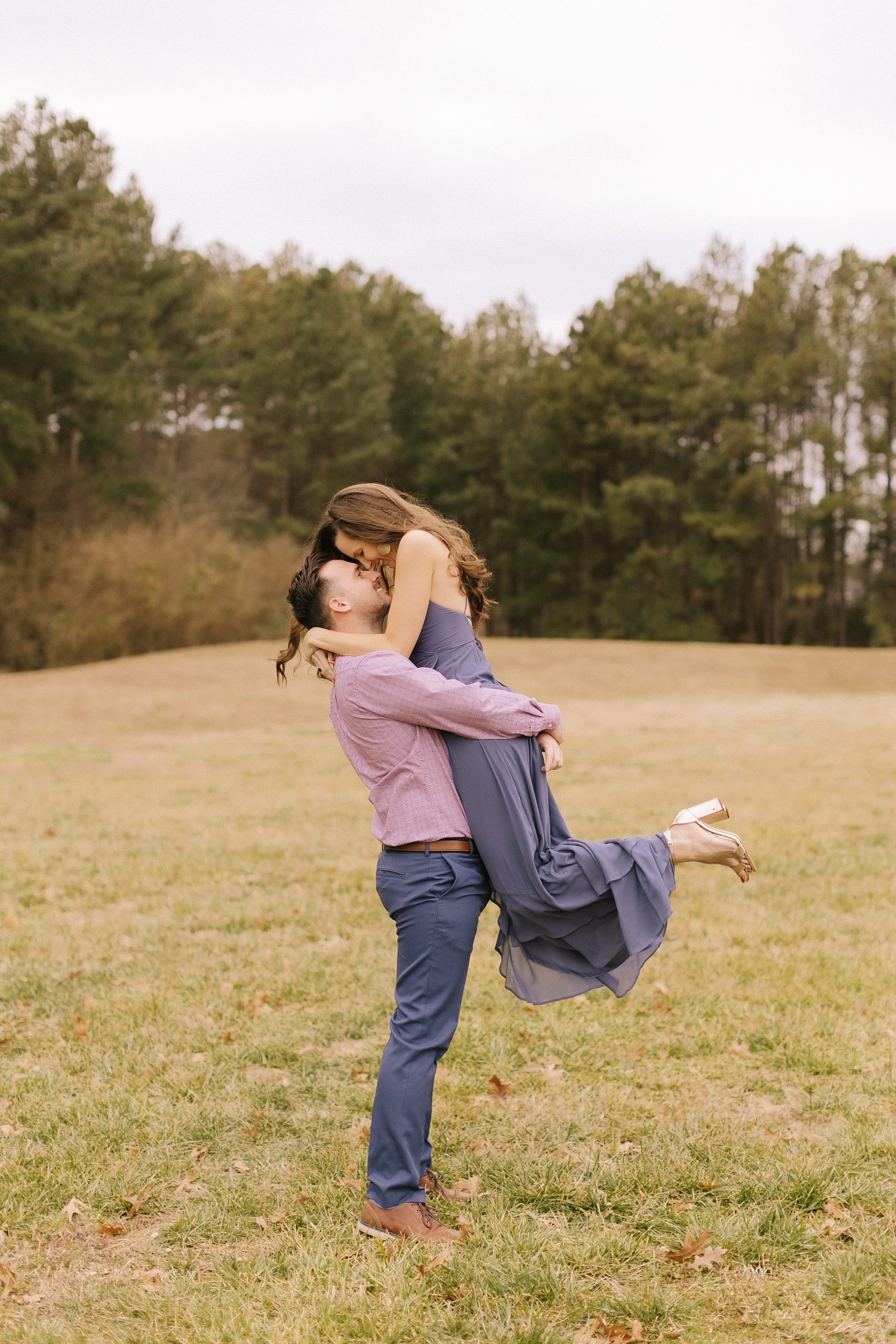 groom lifts fiancee during fall engagement photos 