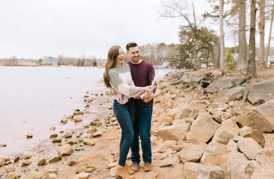 couple pops champagne at their engagement session with winston salem photographer chelsea renay
