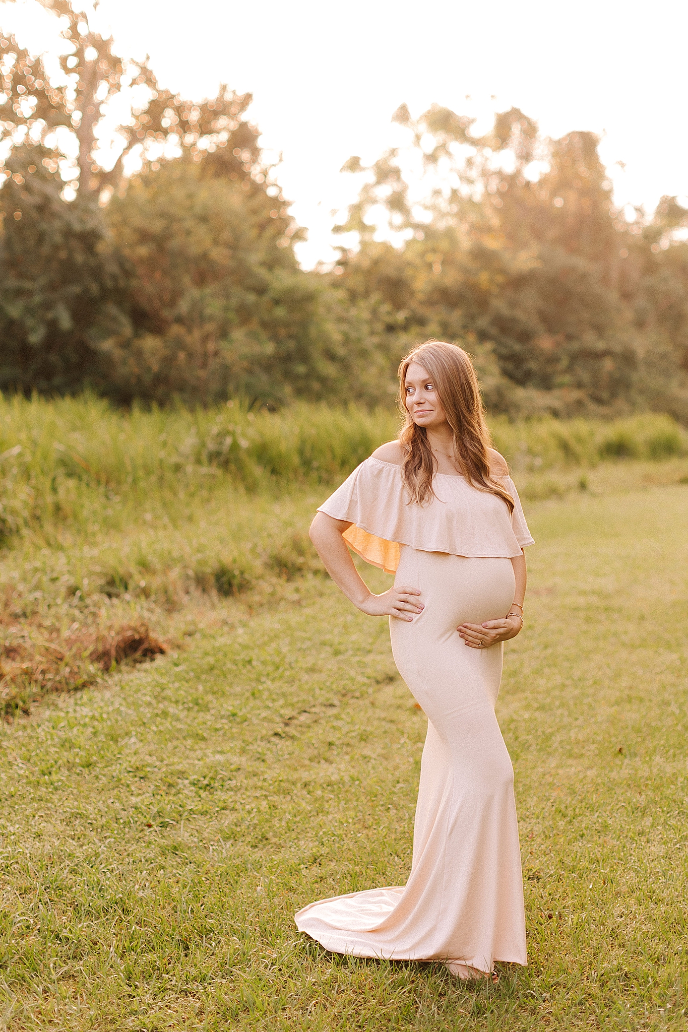 Winston Salem maternity photos on edge of field with mom in pink maternity gown