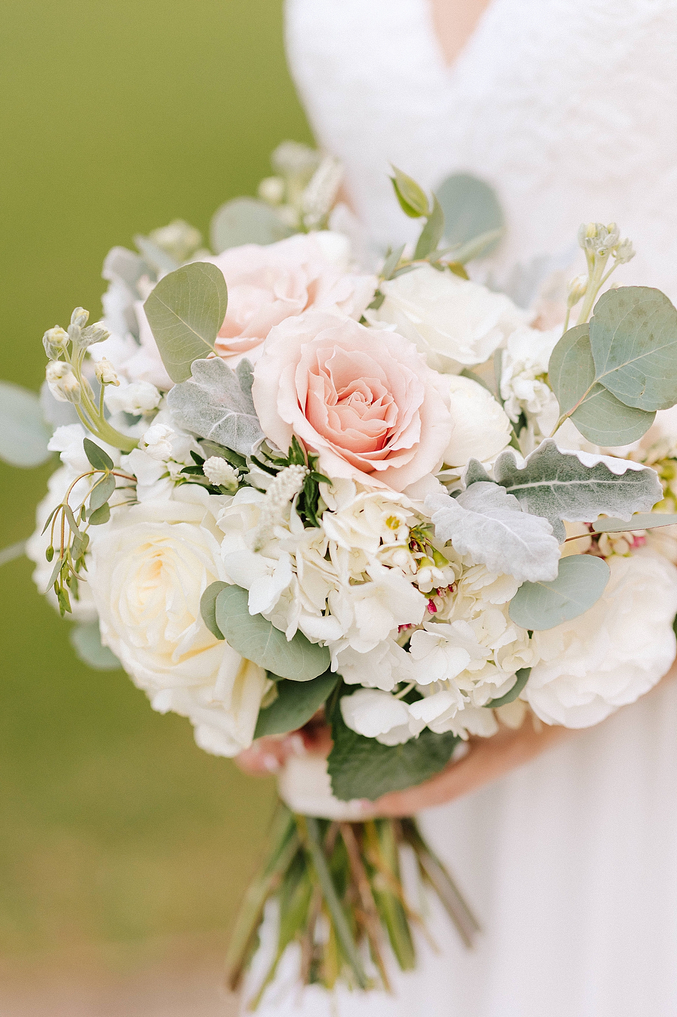 bride holds bouquet of pale pink flowers 