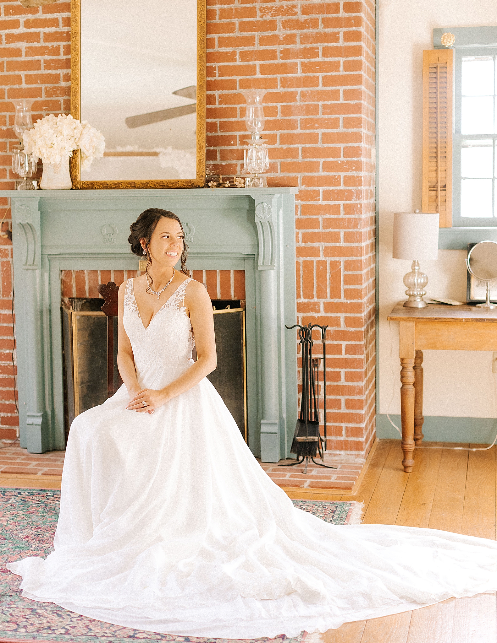 bride poses in front of fireplace at Historic Jasmine Manor