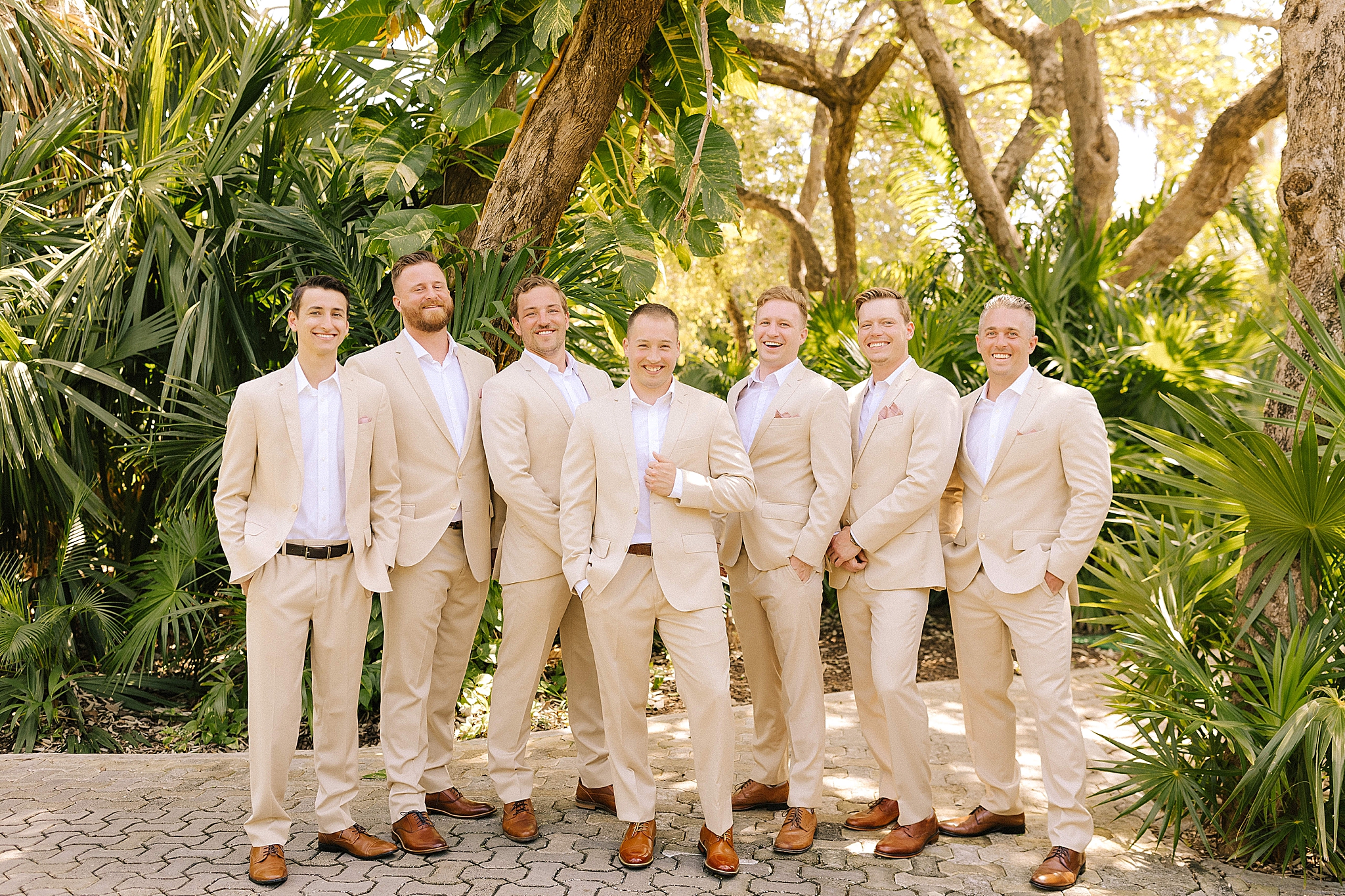 groomsmen pose with groom in tan suit at Playa Del Carmen Destination Wedding