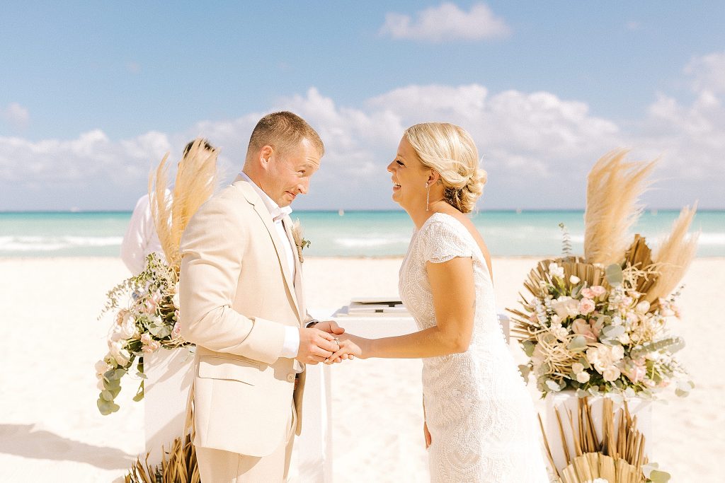 newlyweds laugh during destination wedding ceremony on the beach in Playa Del Carmen