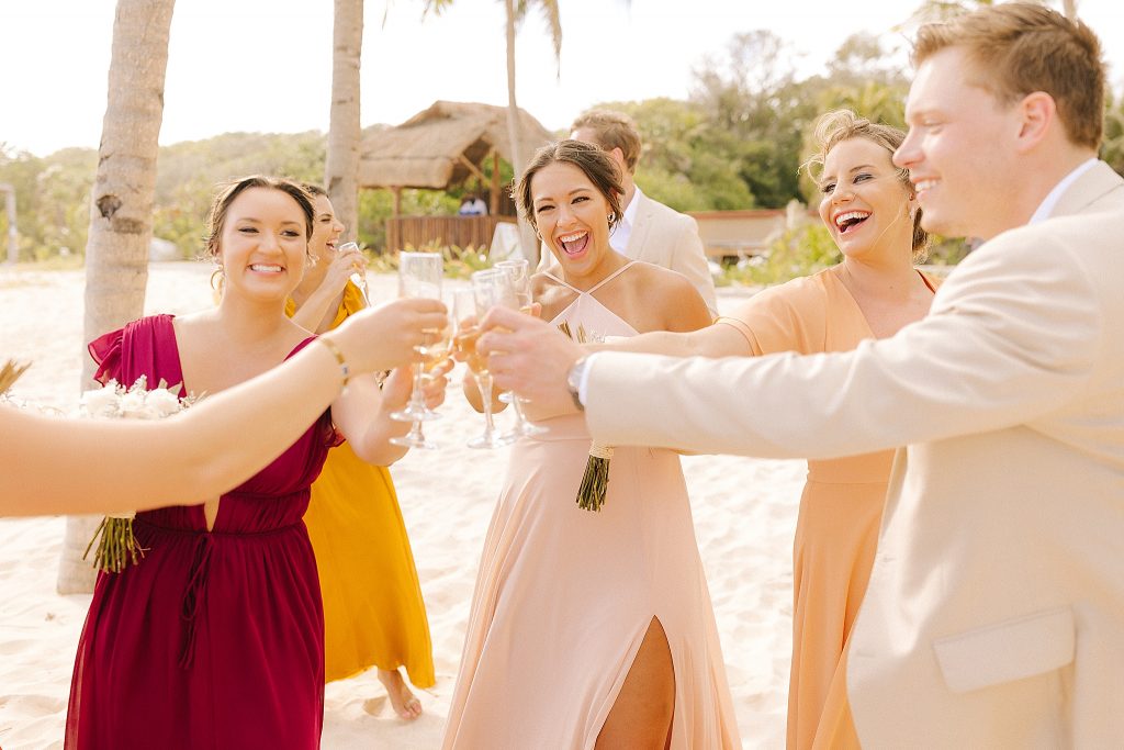 newlyweds toast after Playa Del Carmen Destination Wedding with bridal party