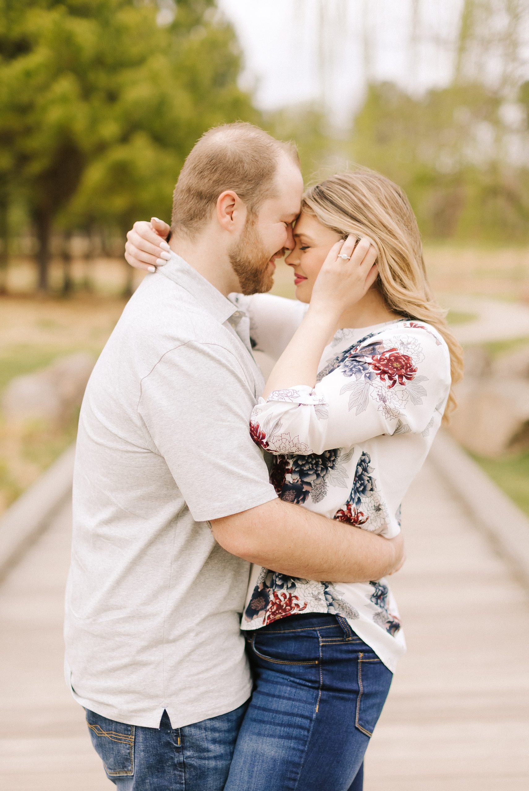 bride pushes hair behind ears during Downtown Raleigh engagement session 