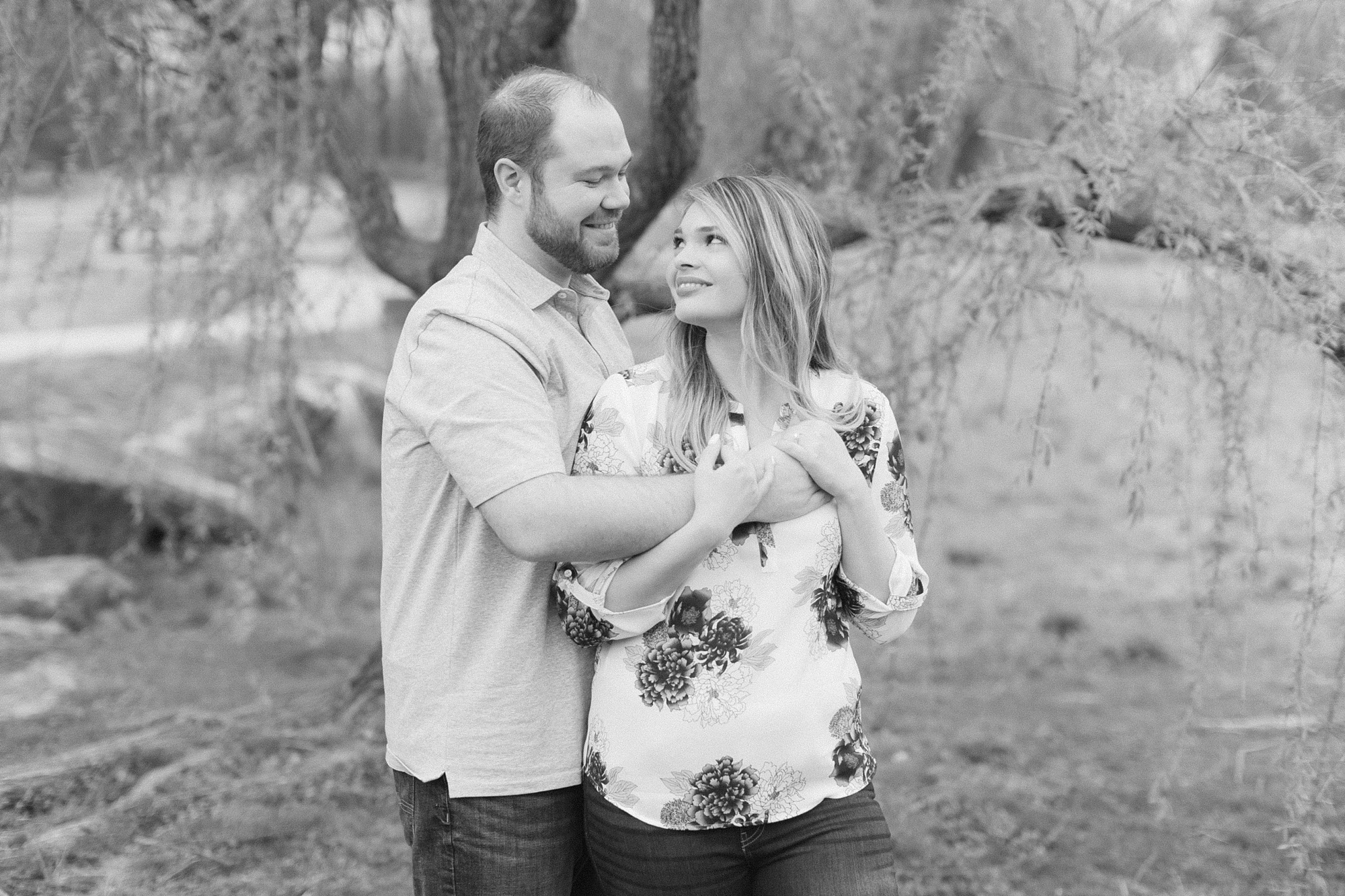 groom hugs bride from behind during Raleigh engagement session 
