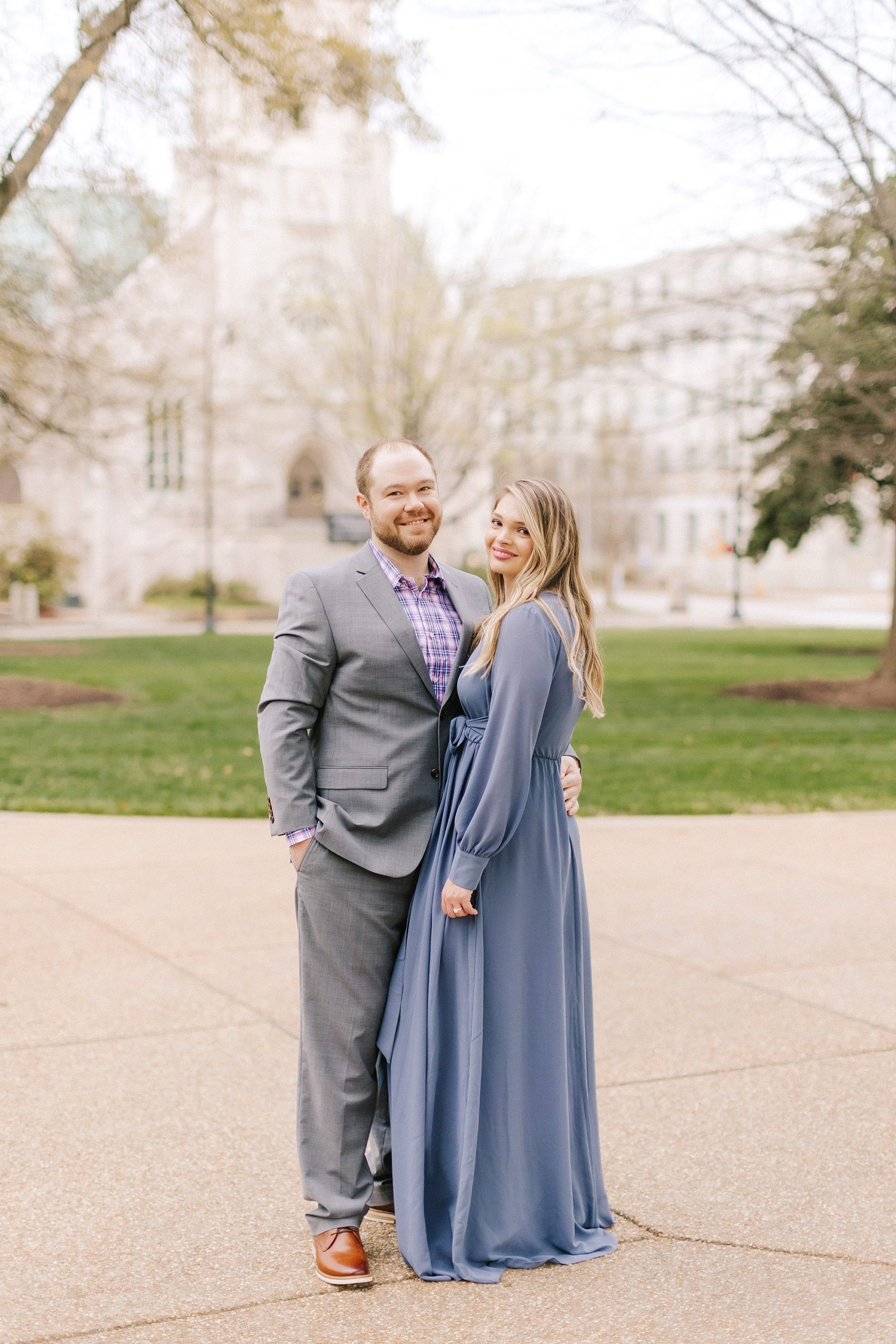 bride and groom pose by city buildings in Raleigh 