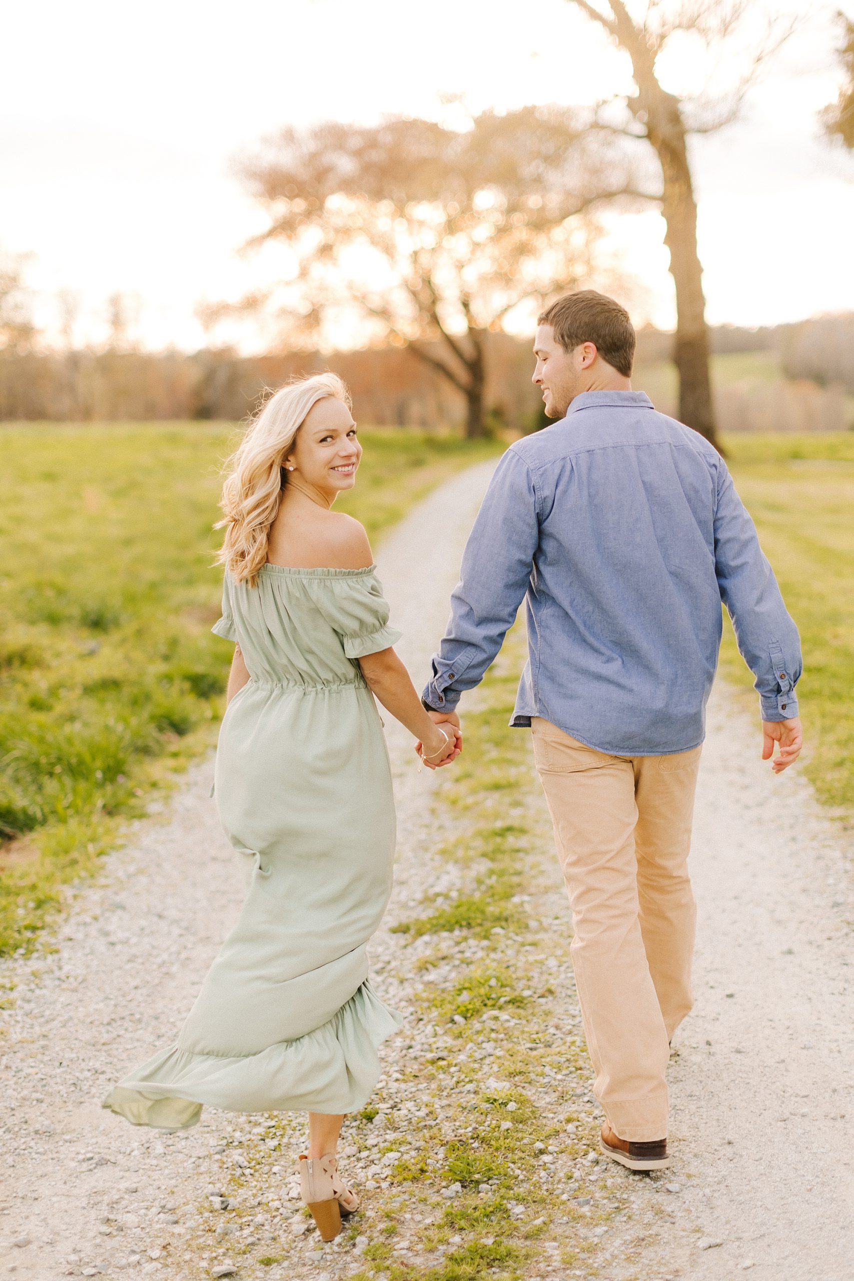bride and groom walk on path during Summerfield Farms engagement session