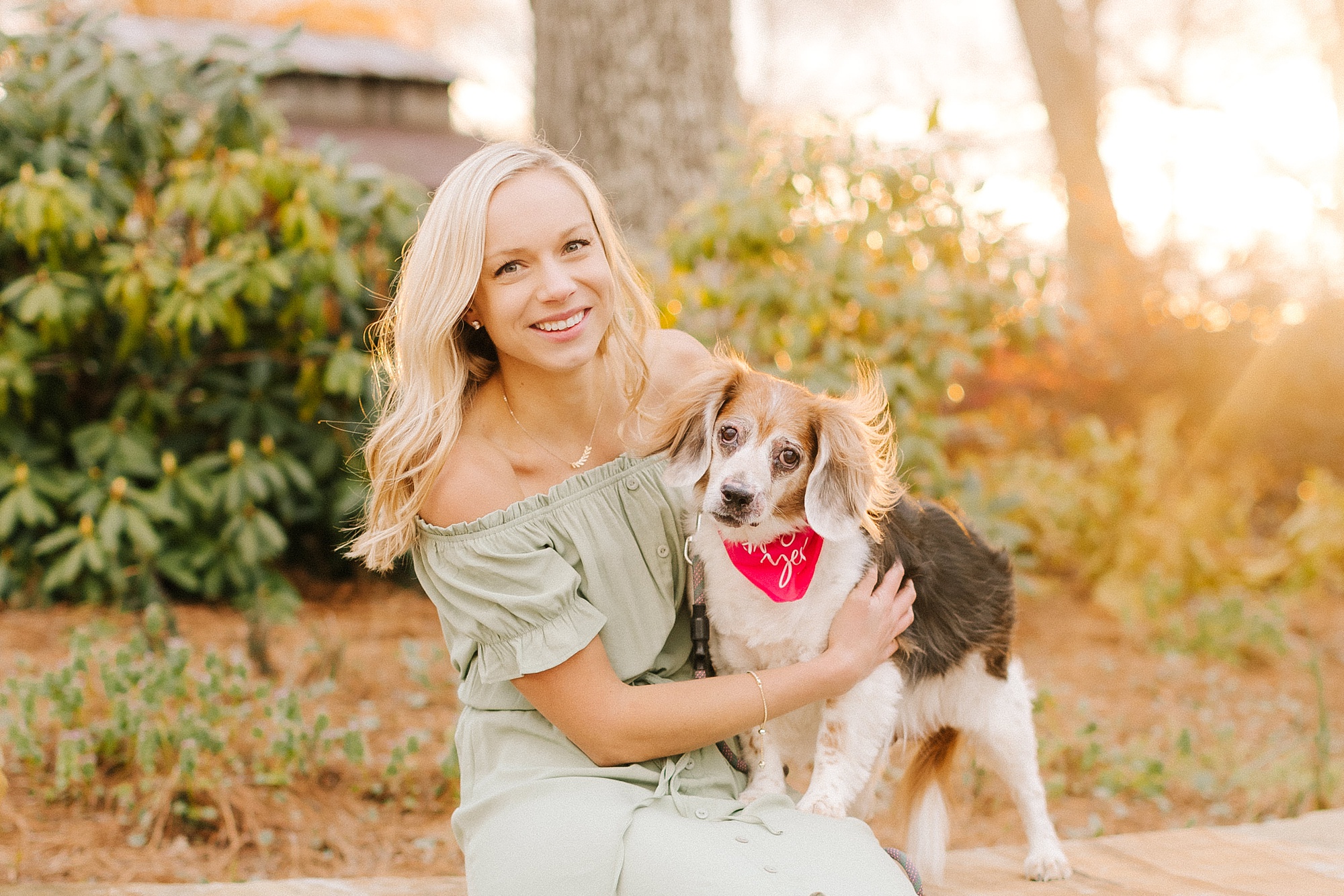 bride pose with dog wearing red bandana during engagement photos at Summerfield Farms